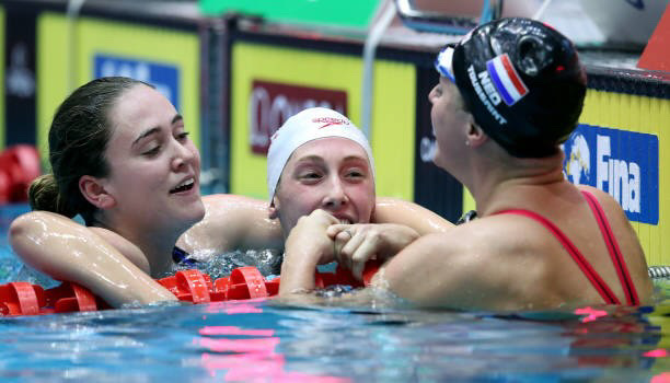 Taylor Ruck celebrating with teammates in the pool at the World Championships