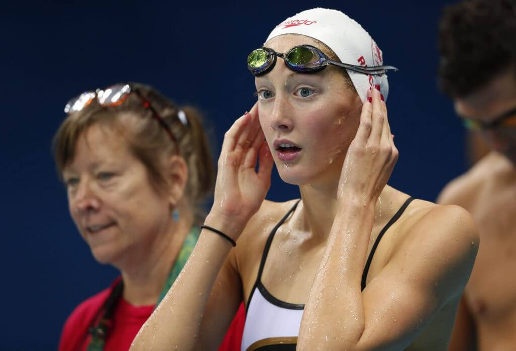 Taylor Ruck on the pool deck at the Rio 2016 Olympic Games with her hands on her swim cap